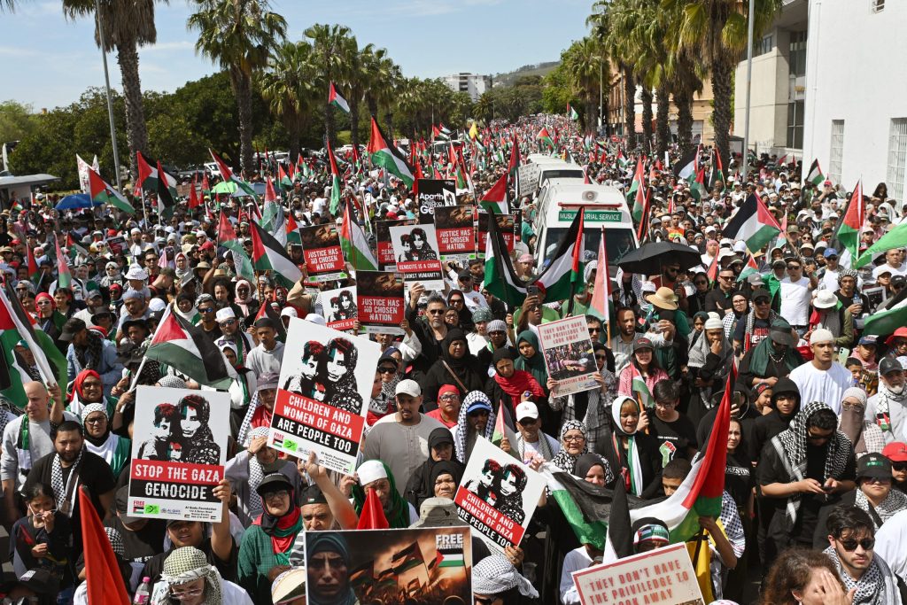 Protesters hold placards and Palestinian flags as they march through the city centre during civil society and faith-based organizations’ mass rally for Gaza, in Cape Town on September 27, 2025.