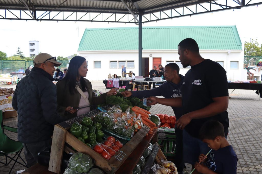 Ansell en Megan Langeveldt help kliënte van Veldt Fresh om al hul groente vir die week aan te skaf. Ansell is 'n plaaslike boer met bedrywighede en Veldt Fresh was een van die eerste stalletjies by die weeklikse mark. Foto: Yaël Malgas
