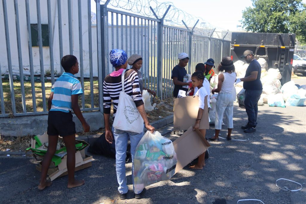 Inwoners staan gereed met hul hernubare afval om aan beamptes van die Stellenbosch-munisipaliteit te oorhandig tydens Cloetesville se eerste Swop Shop. Foto: Yaël Malgas