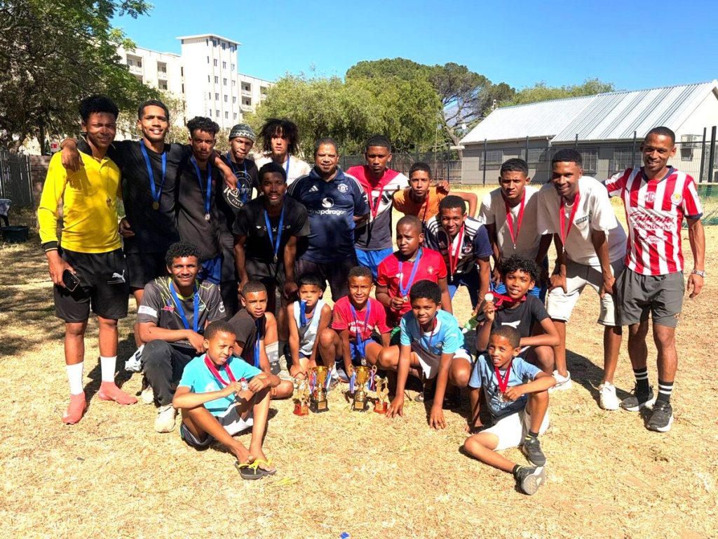 The junior youth and senior winners with the organisers, Mickyle Joshua (behind, far left) and Luqmaan Manuel (behind, far right) and Ashley Davidse of the 
Stellenbosch Local Football Assocation after the tournament's prize-giving ceremony.