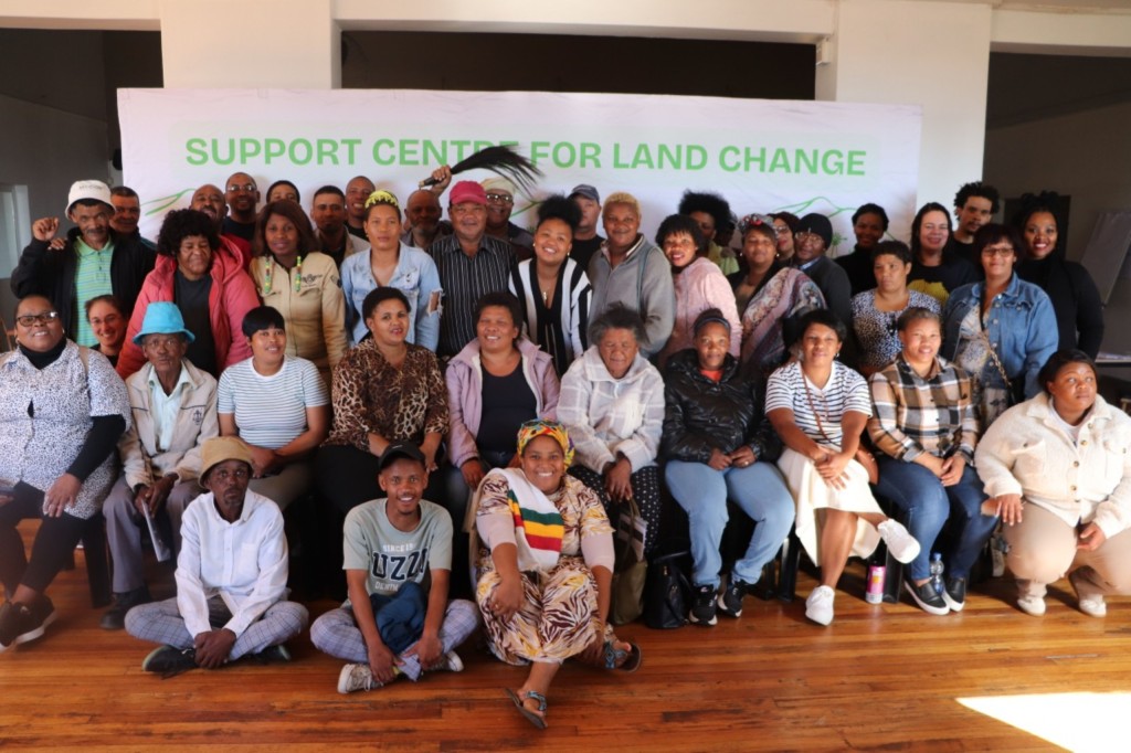 A large group of people sitting and standing alongside each other.