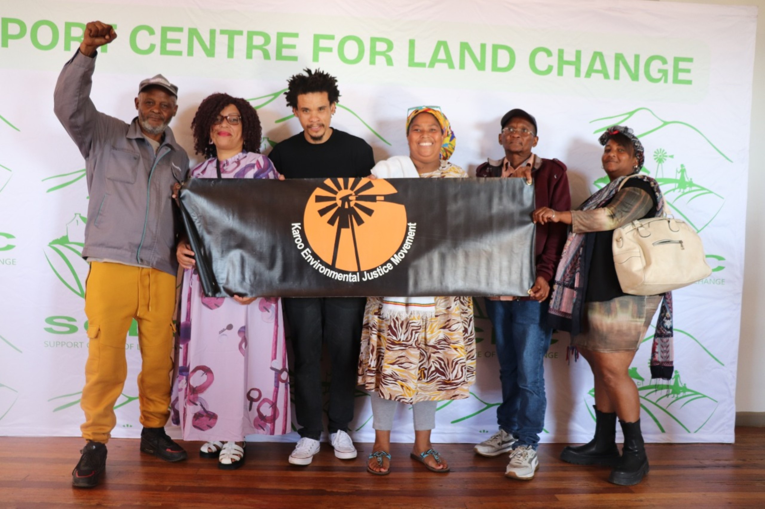 A group of six people standing with a poster with the words "Karoo Environmental Justice Movement".