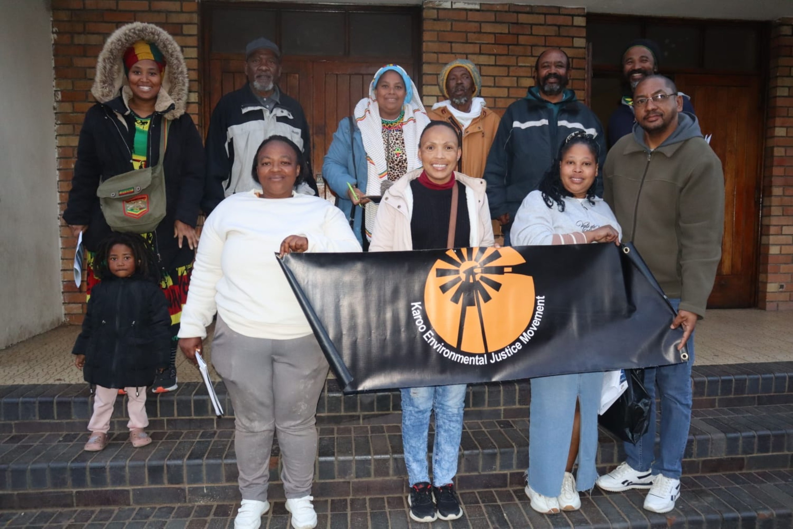 A group of people standing next to each other with a large poster.