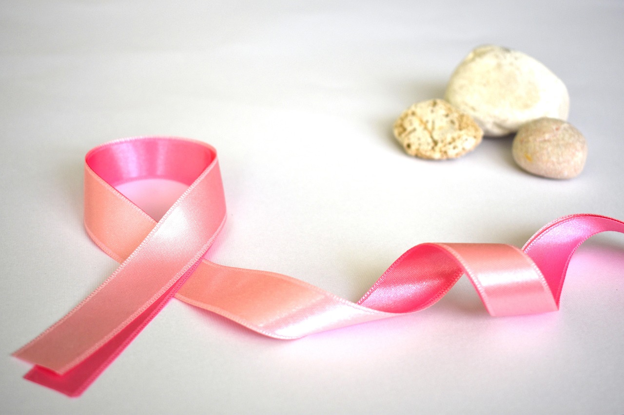 A pink ribbon with stones alongside it.