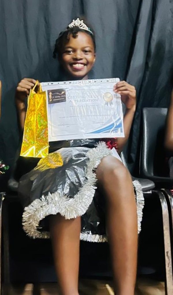 Zukhanye Ndawo sitting down with a certificate.