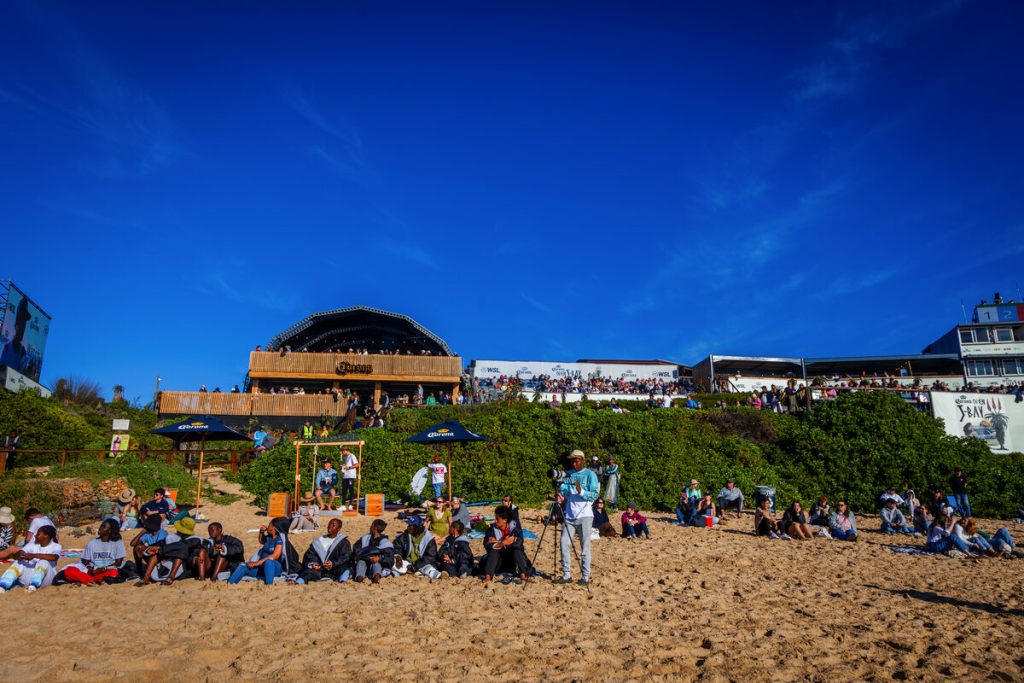 A group of people sitting on the beach.