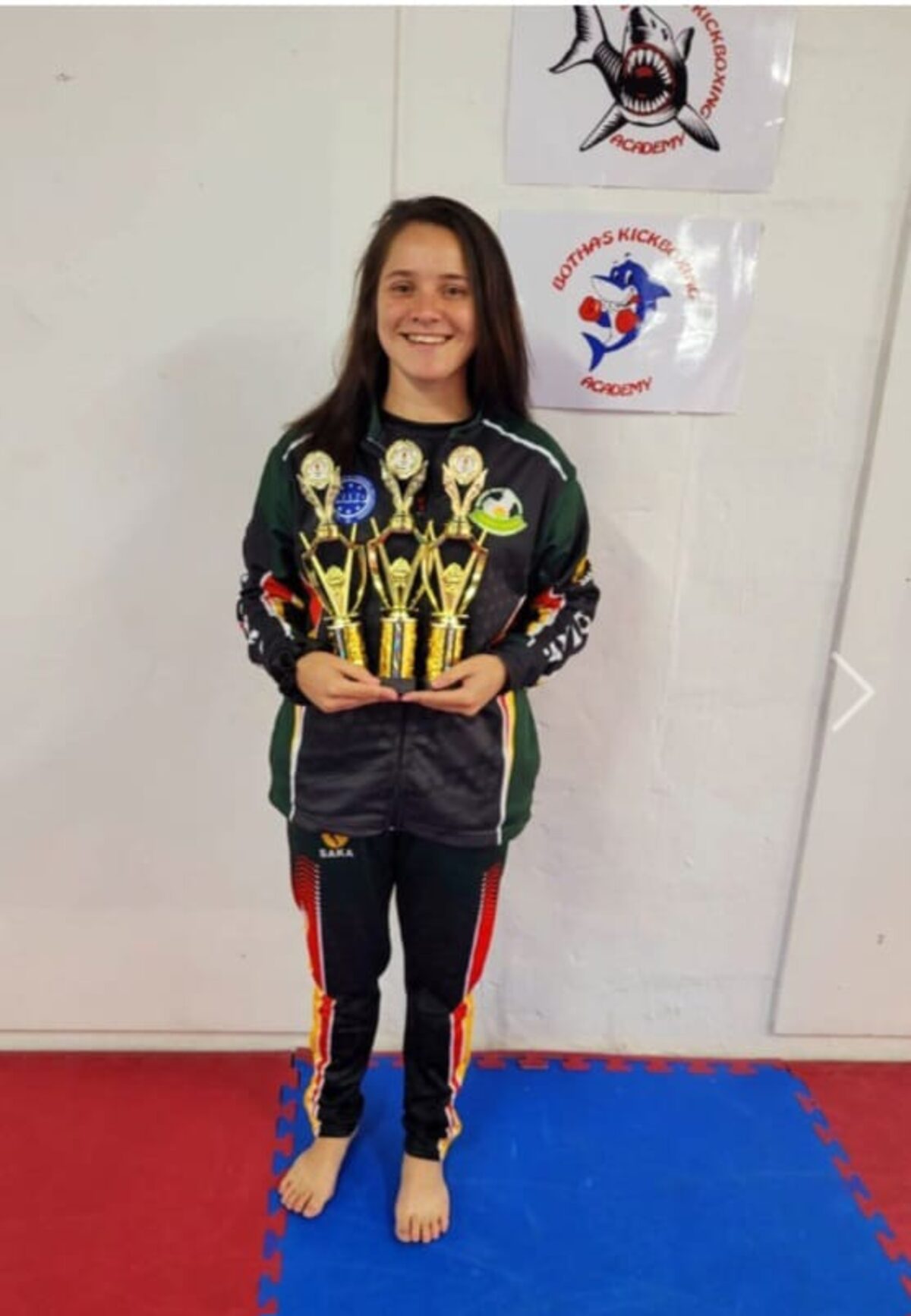 Taylor Urquhart holding multiple trophies.