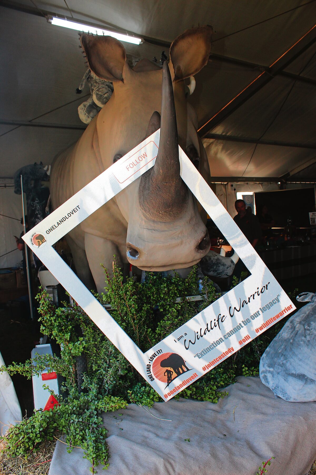 A fake rhino with a selfie poster hanging from its horn.