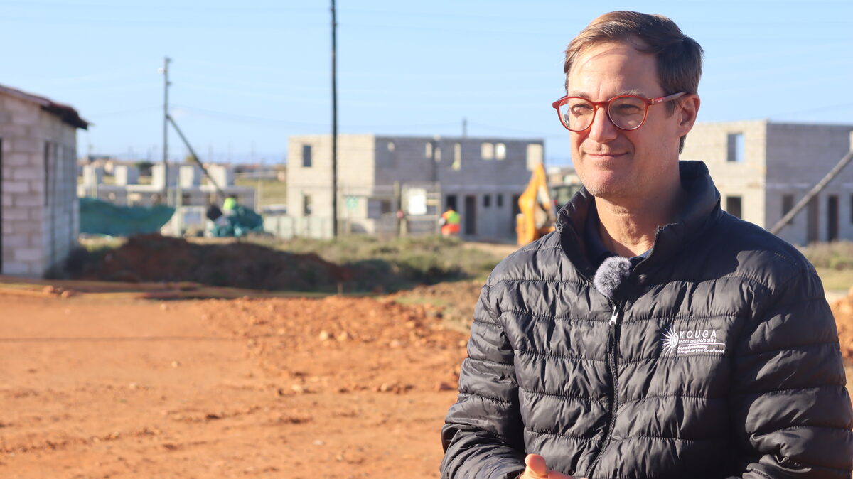 Kouga Executive Mayor, Hattingh Bornman, standing in front of newly built homes.