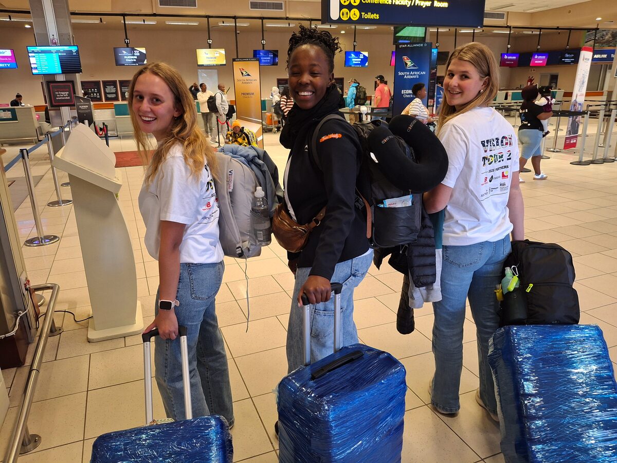 Three learners at the airport with their luggage.
