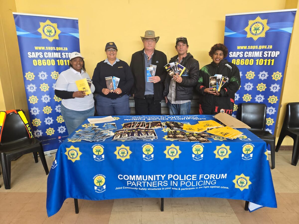 A group of people standing at a table with SAPS themed décor all around.
