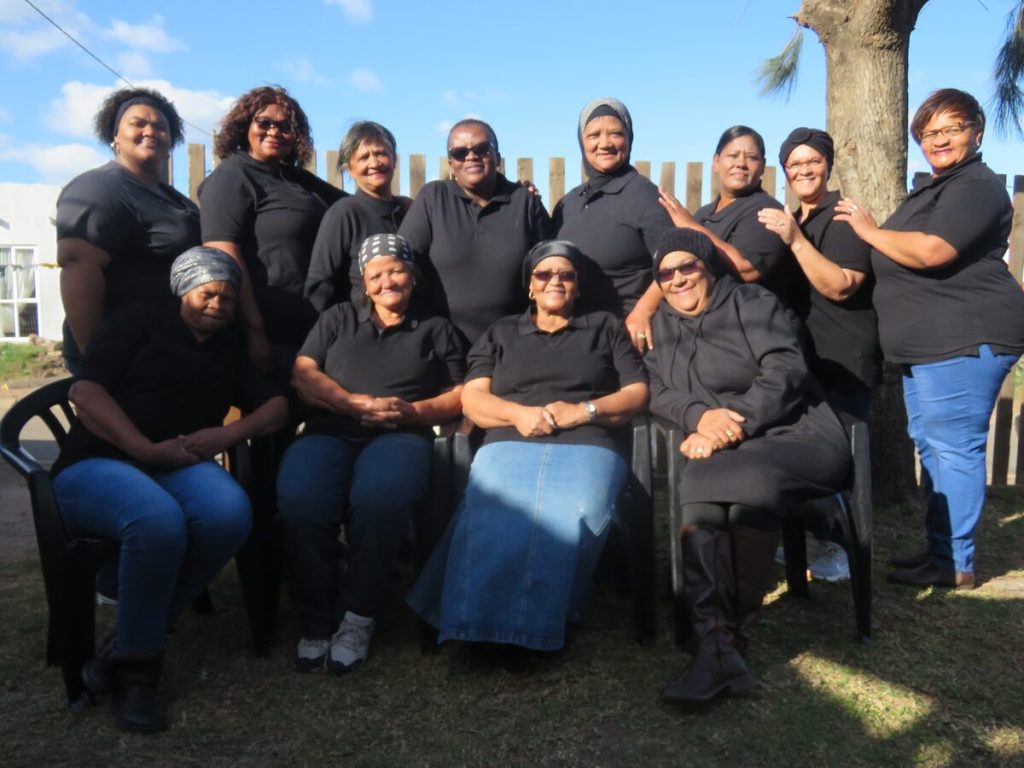 A large group of women standing alongside each other.
