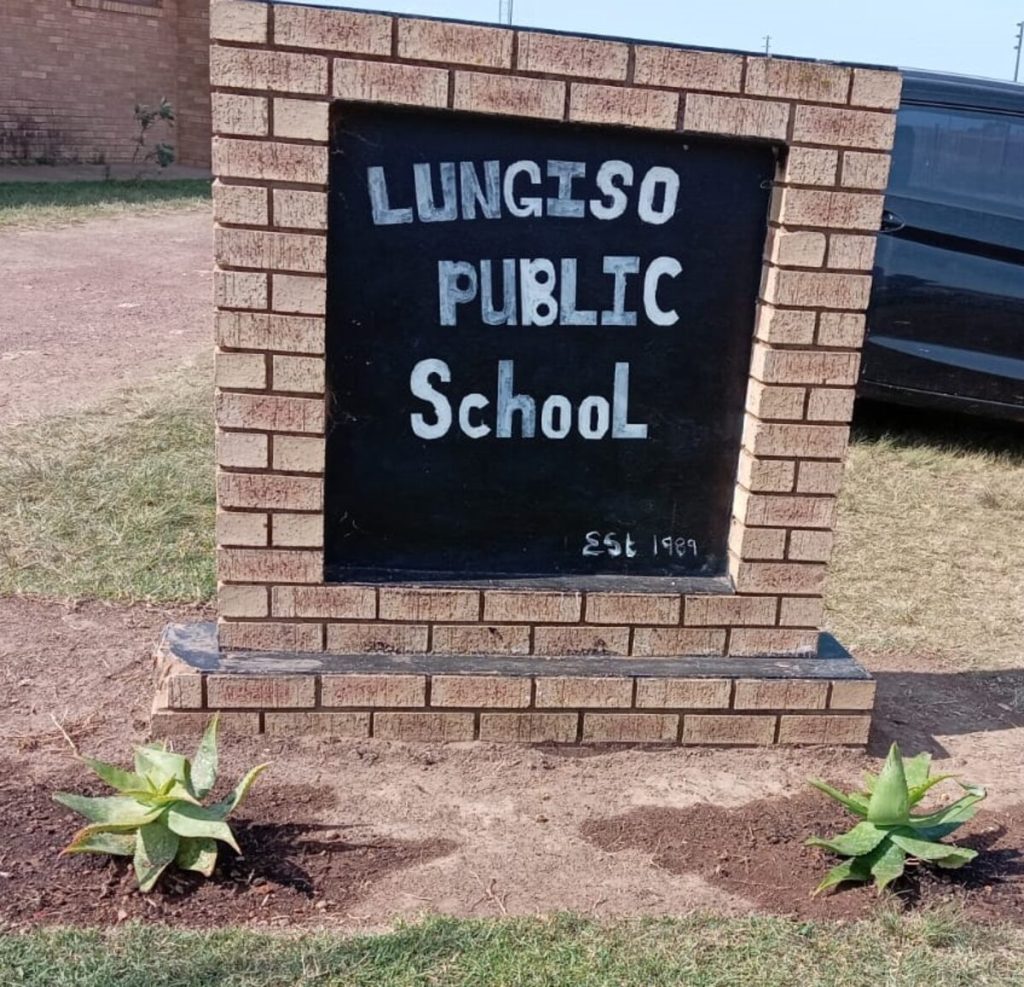 New plants in front of the school's signage.