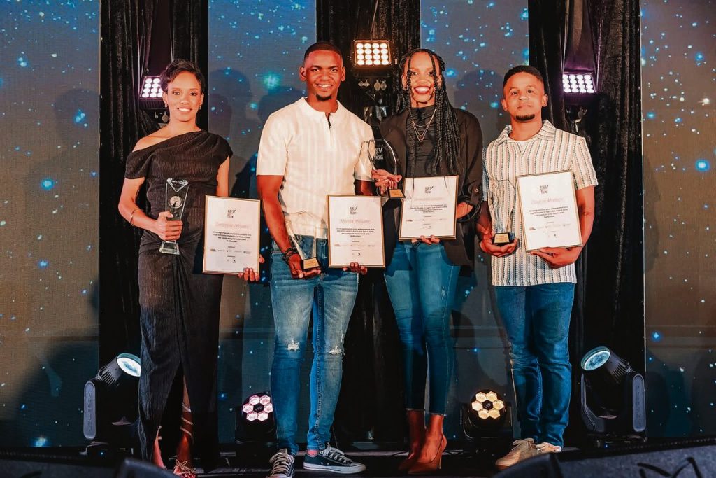 The four finalists standing alongside each other holding their certificates.