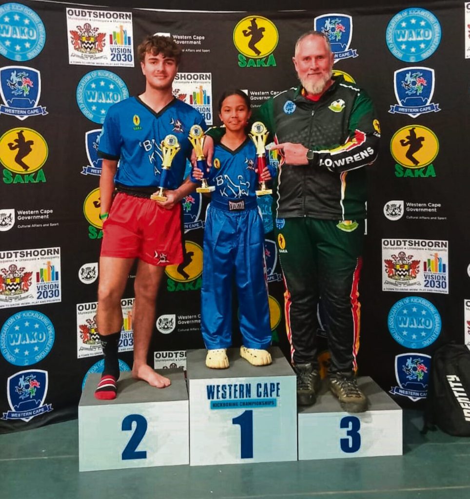 Three people standing alongside each other on a stage.