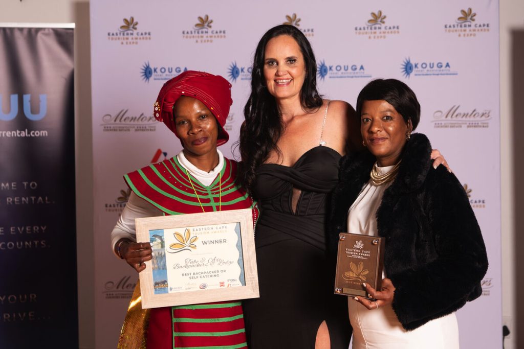 Three people standing alongside each other showcasing their awards.