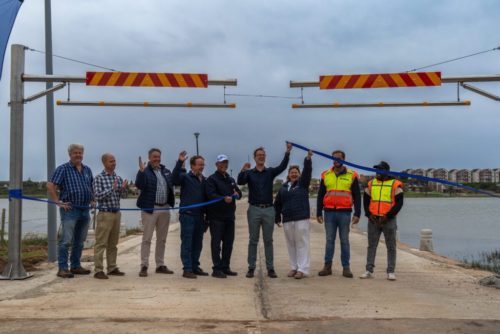 A group of people standing at the entrance of the Seekoei Estuary Causeway.