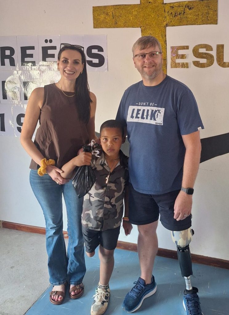 Doreen Pieters standing next to Oluthando Nkosinkulu who has an amputated leg and Riaan Miles who has a prosthetic leg.