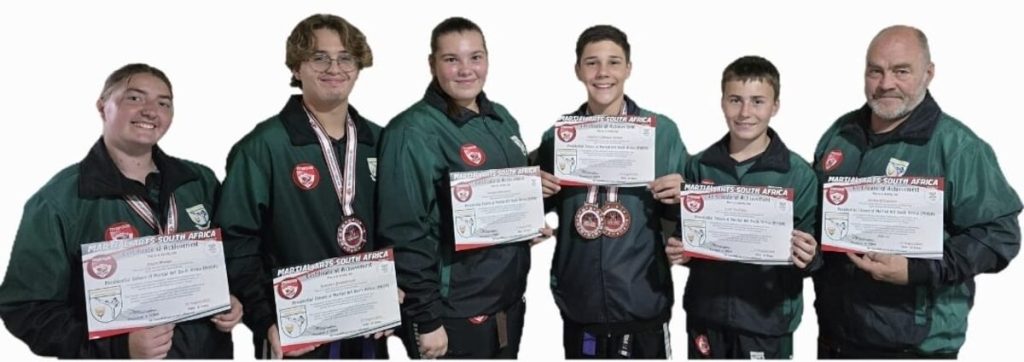 A group of people standing alongside each other holding their certificates.