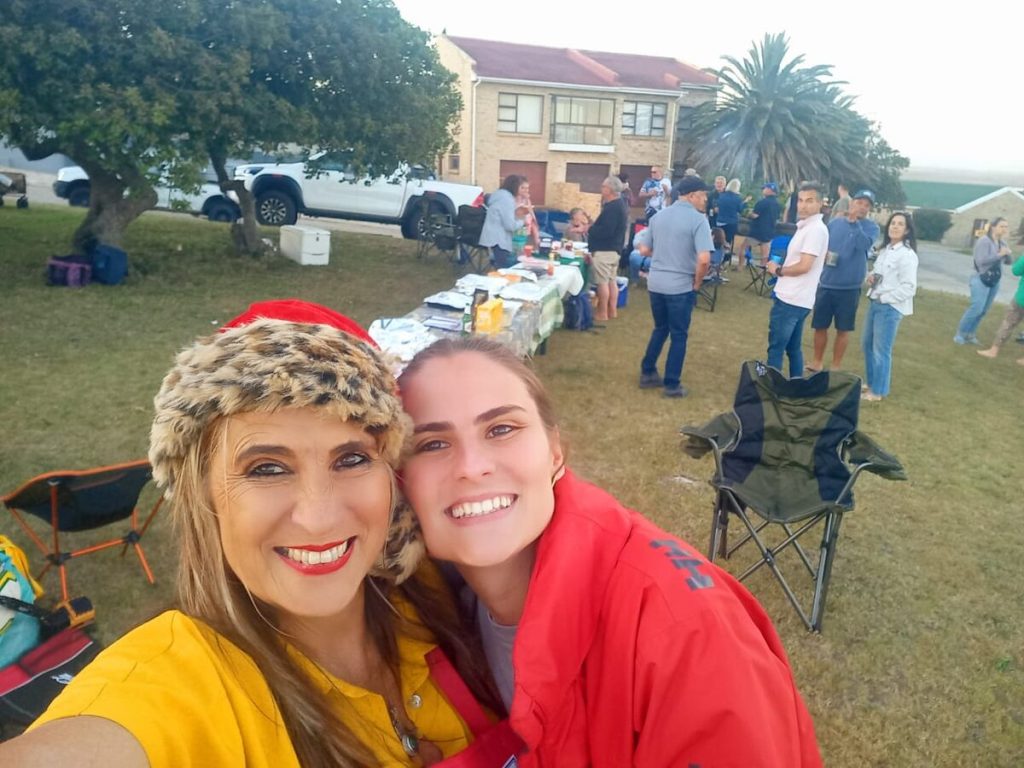 Soria Swart and her daughter Grietjie Burger with people gathering in the background.
