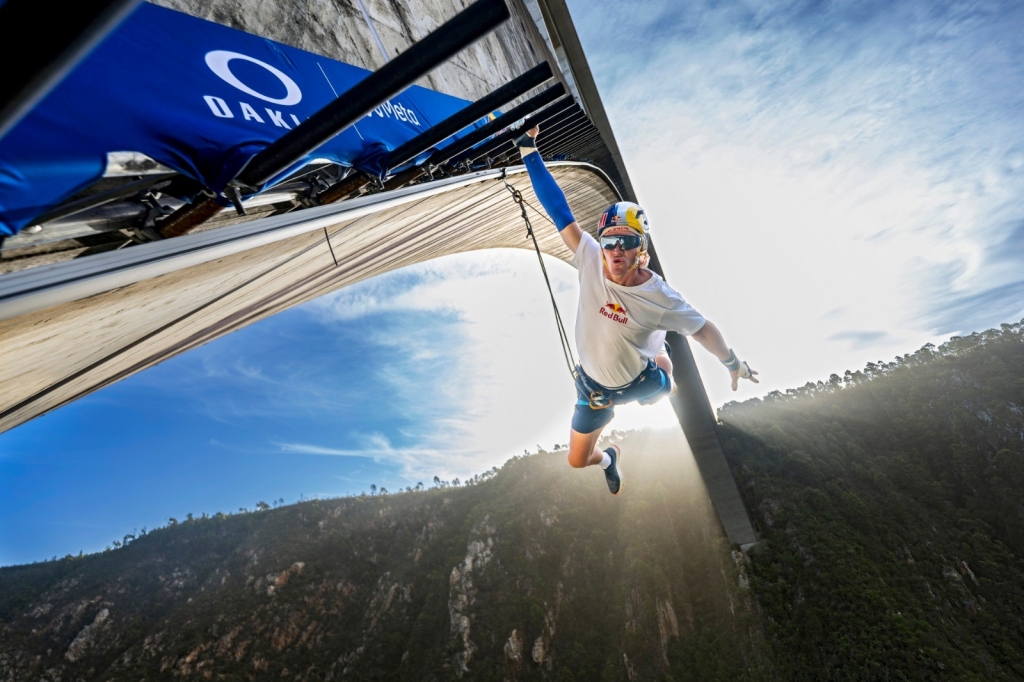 Thomas van Tonder grips his way across 600 monkey bars suspended 216 metres above the river.