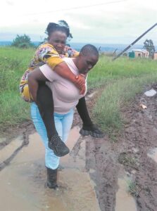 Access road’s condition forces daughter to carry mother
