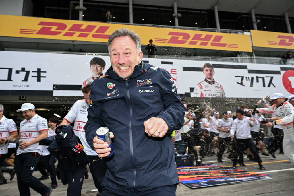 Red Bull Racing's British team principal and CEO Christian Horner (C) reacts as members of his team celebrate the victory by Red Bull Racing's Dutch driver Max Verstappen (far R) after the Formula One Japanese Grand Prix.