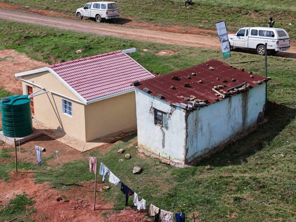 The newly built Nqweniso family home in juxtaposition with the old mud structure.