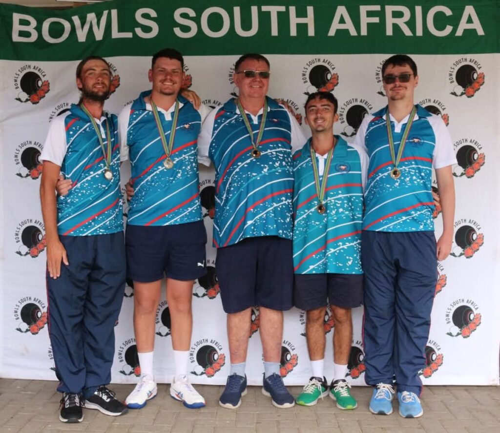 The junior team taking home a bronze medal, with their manager. 
