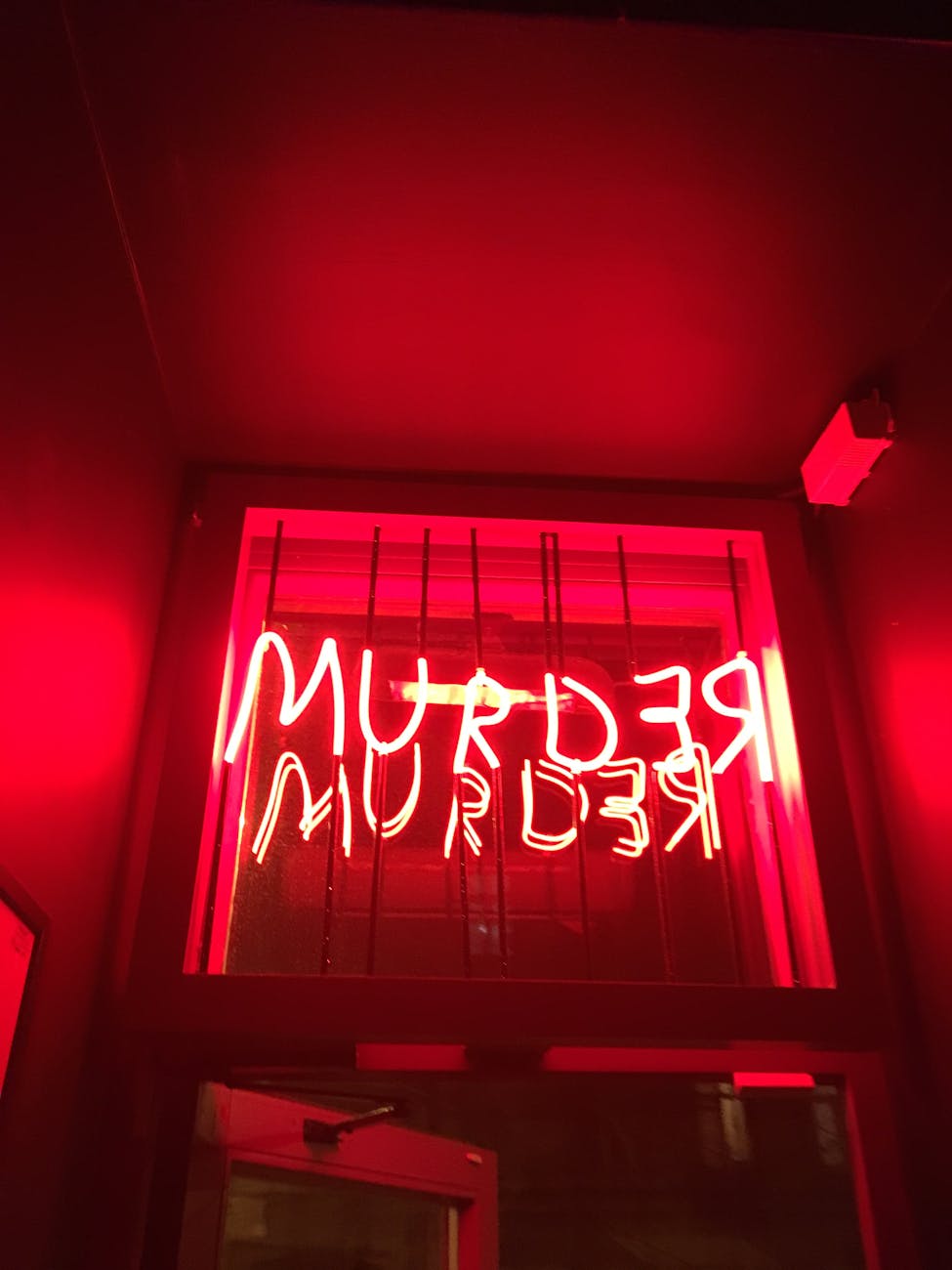 murder neon text on window with bars