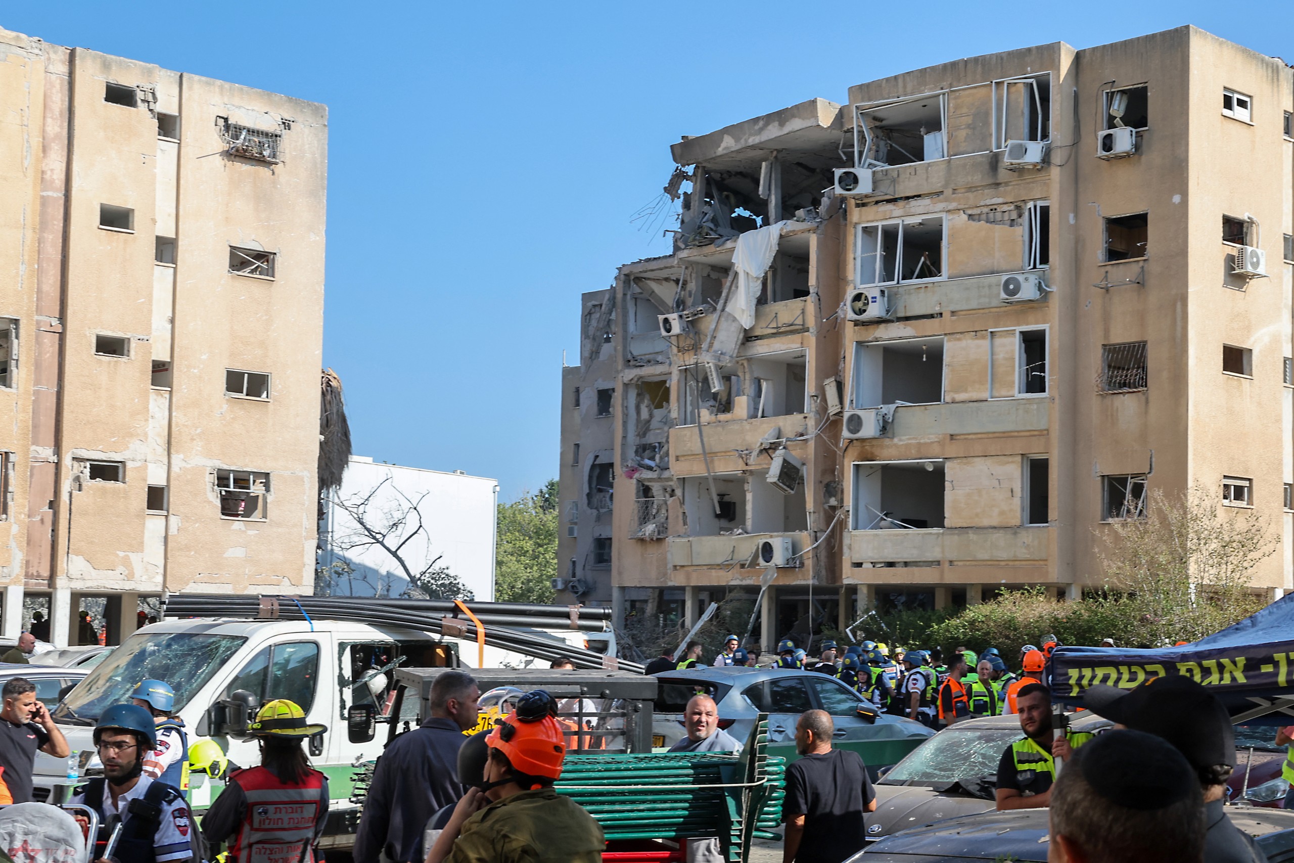 Israeli emergency services work at the site of an Iranian missile attack in a residential area in Holon in central Israel this morning, 19 June. PHOTO: AFP