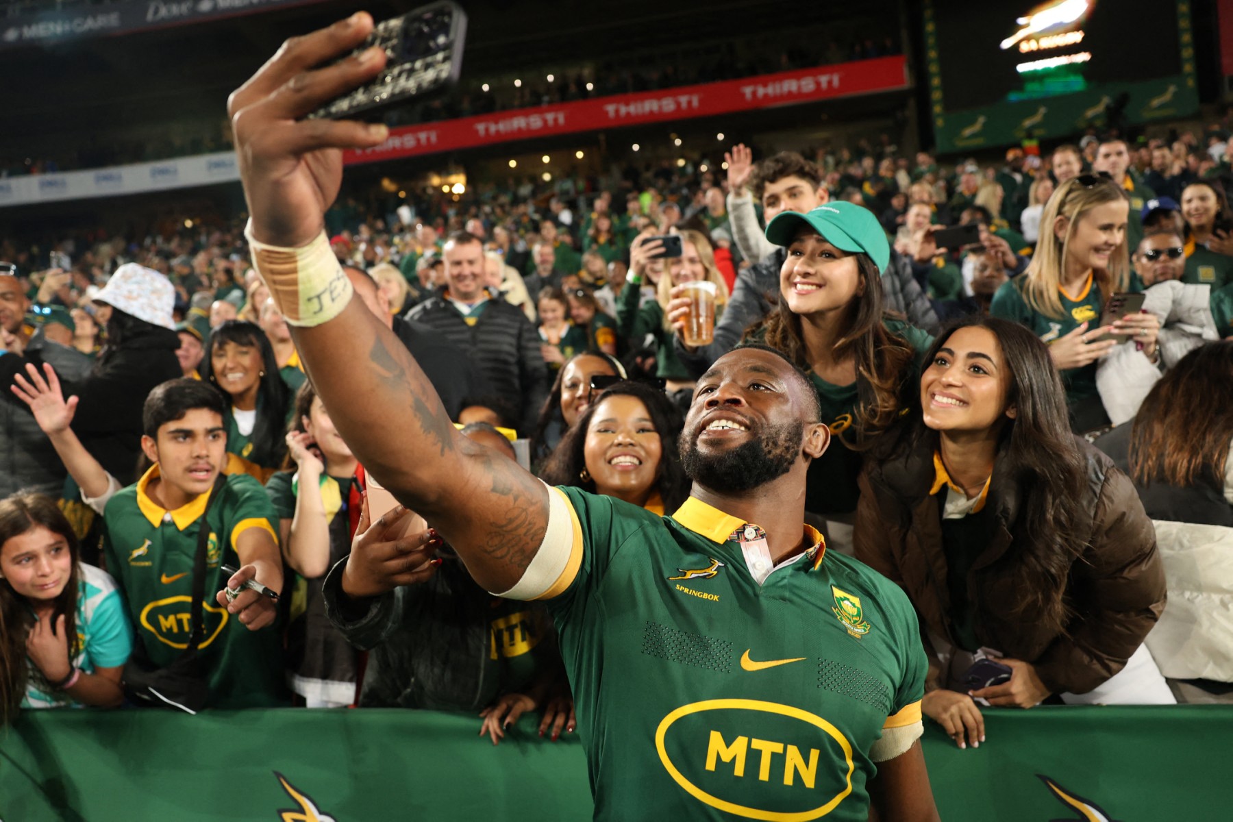 South Africa's flanker Siya Kolisi takes a selfie with supporters after South Africa won the Rugby Championship