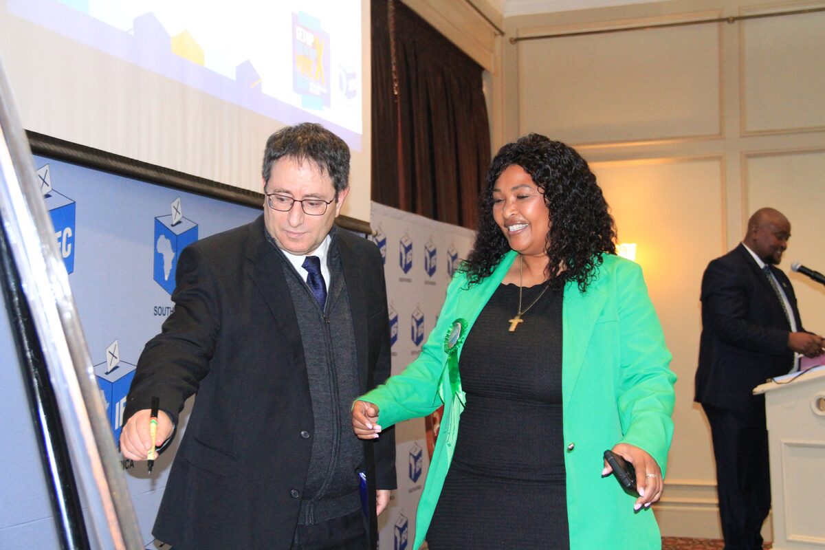 Regter Lawrence Lever wys vir Renate Benjamin, PA se provinsiale voorsitter, waar sy die gedragskode moet onderteken.