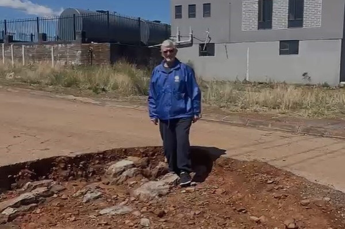 Braam van der Westhuizen, DA-raadslid, wys hoe diep van die gate in die paaie is.