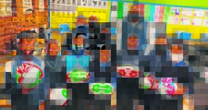 Rugbyspeler skenk netbal- en rugbyballe