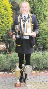 Larries se atleet Elke ryg die trofeë en medaljes in