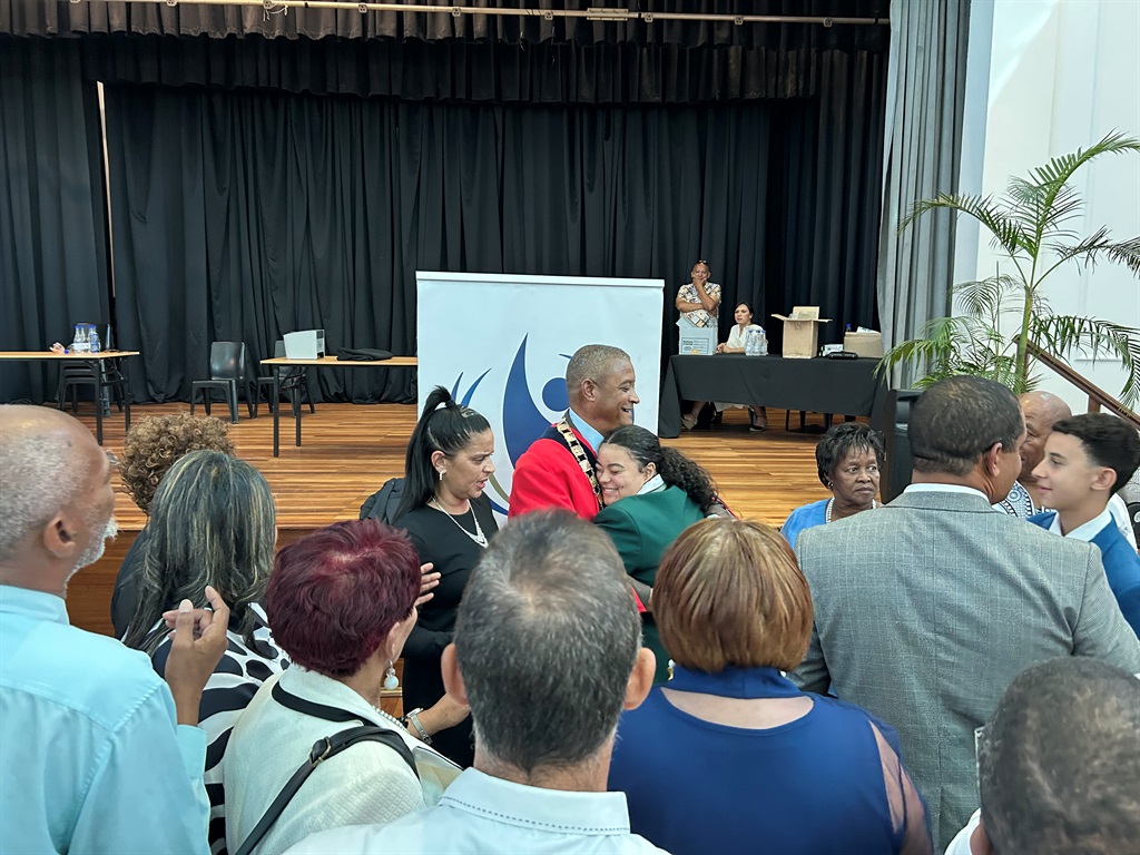 Korabie word deur familielede en kollegas omhels. 