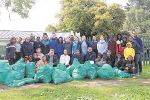 Youth pick rubbish up on the edges of the Berg River