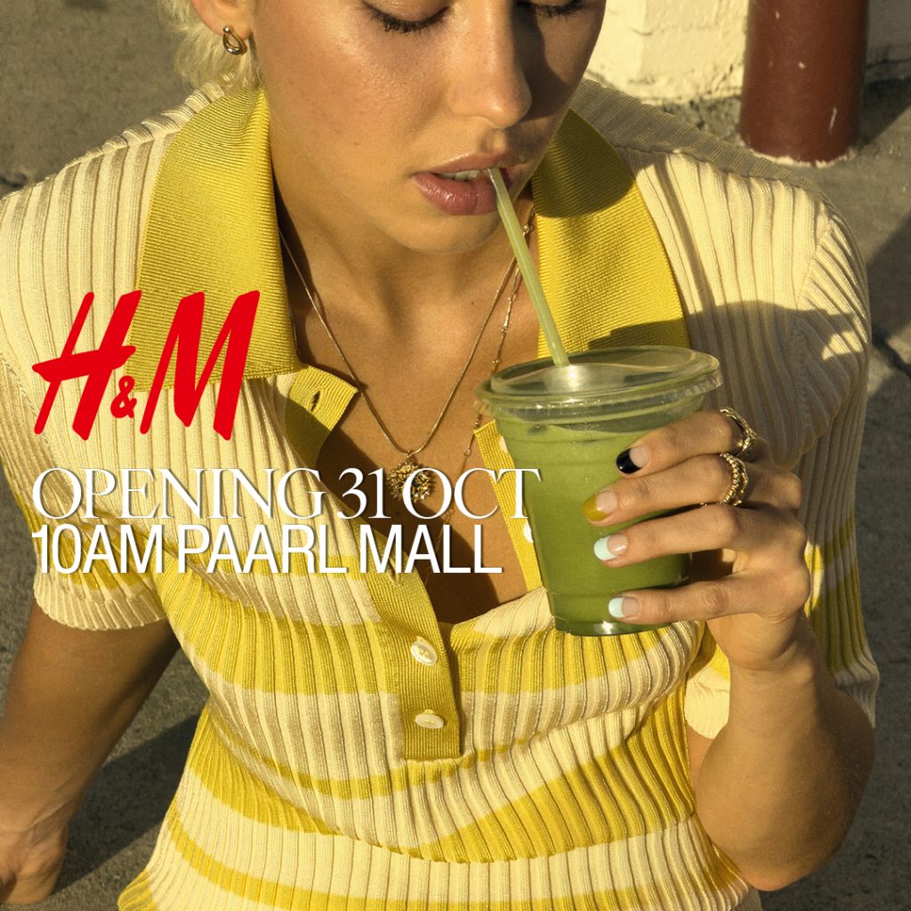 H&M Paarl Mall opening campaign featuring a woman in a yellow striped top holding a green drink.