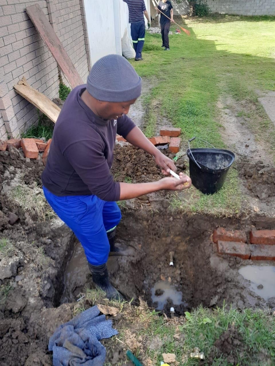 Plumbers busy fixing a water leak.