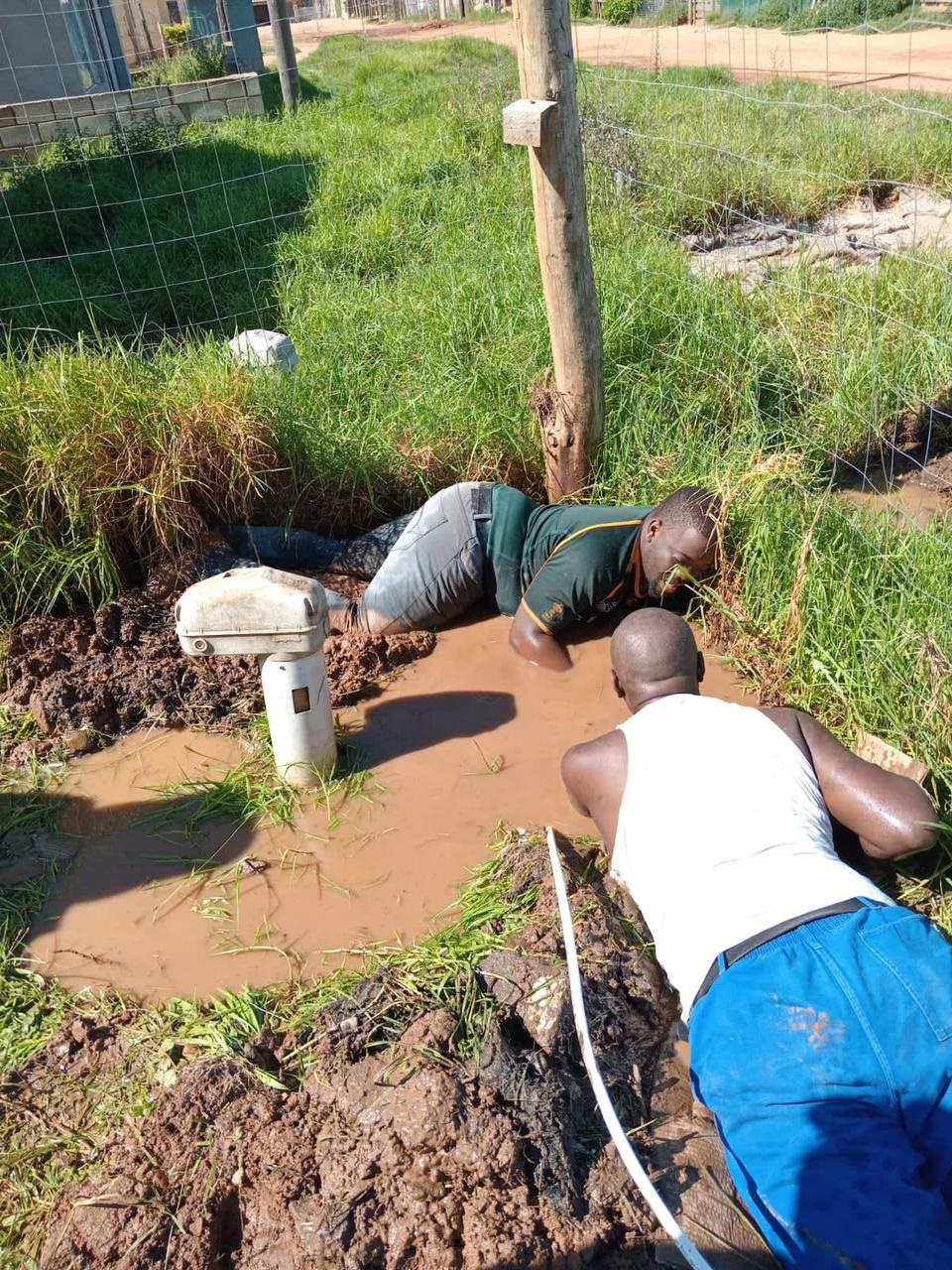 Plumbers busy fixing a water leak.