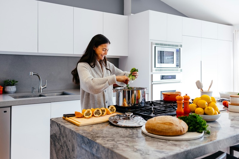 A woman preparing a healthy meal in a modern kitchen, supporting bipolar disorder management through diet.