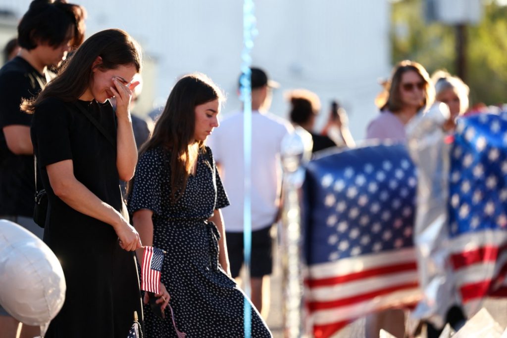 People gather at a makeshift memorial for right-wing activist and Turning Point USA Founder Charlie Kirk outside of the Turning Point USA headquarters in Phoenix, Arizona, on September 14, 2025. The widow of prominent right-wing activist Charlie Kirk pledged on September 12 to carry on her husband's work, after US authorities announced his alleged assassin had finally been captured. The 31-year-old Kirk was hit by a single bullet while addressing a large crowd at Utah Valley University in the town of Orem on September 10. (Photo by Charly Triballeau / AFP)