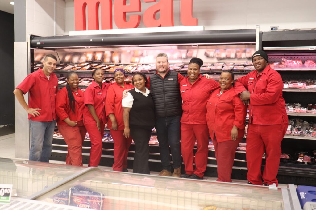 Team of SUPERSPAR Waterfront employees in front of a butchery fridge.
