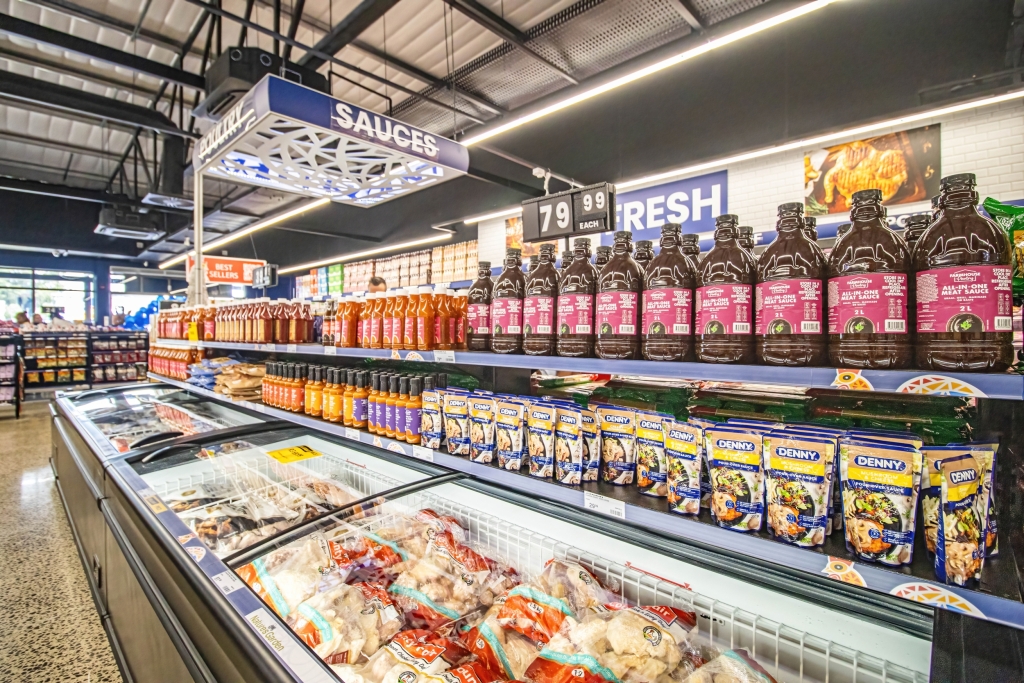 Fully stocked sauce shelves and frozen food section at Econo Foods.