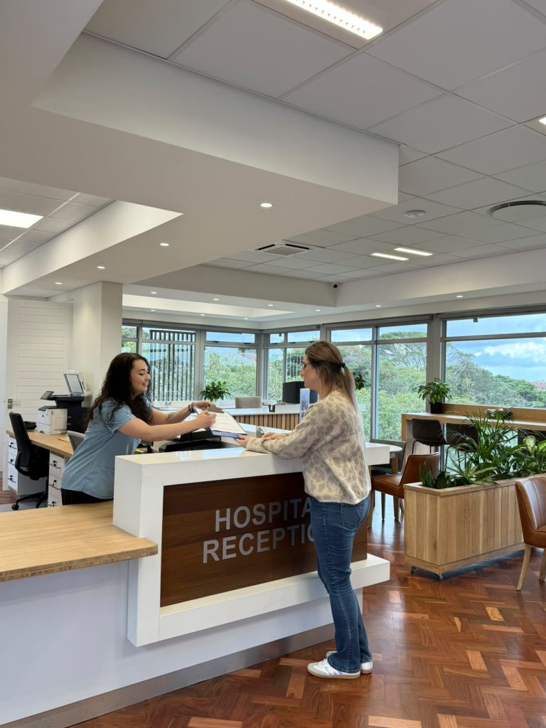 Reception staff assisting a patient at Edge Day Hospital in Gqeberha.