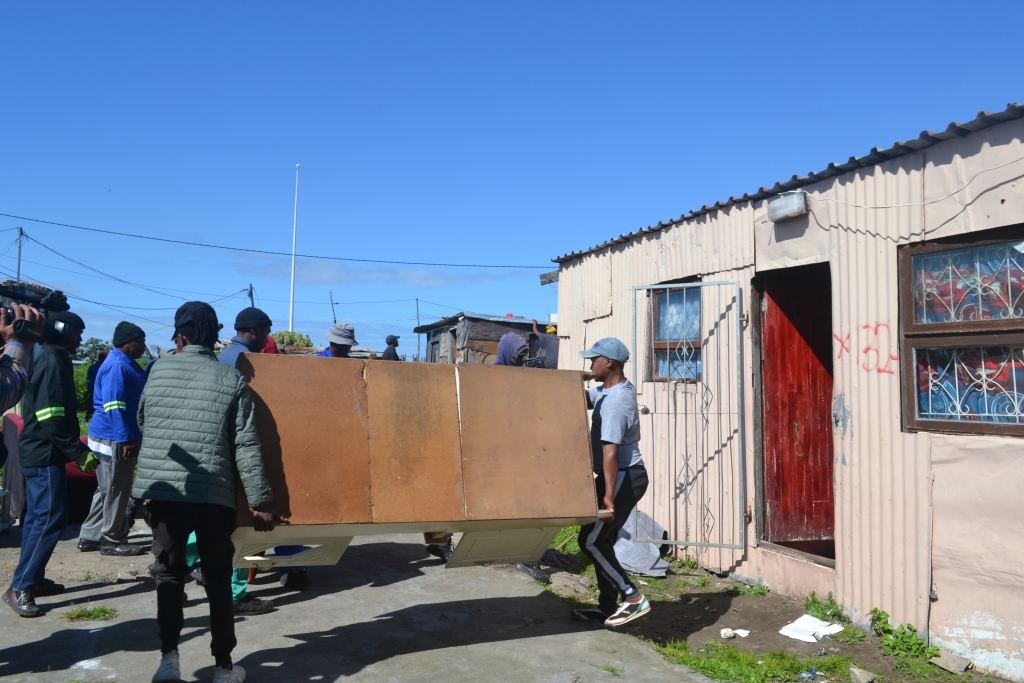 Residents hurriedly remove furniture from the informal structure Nwabisa Yamiso had called home for four years.