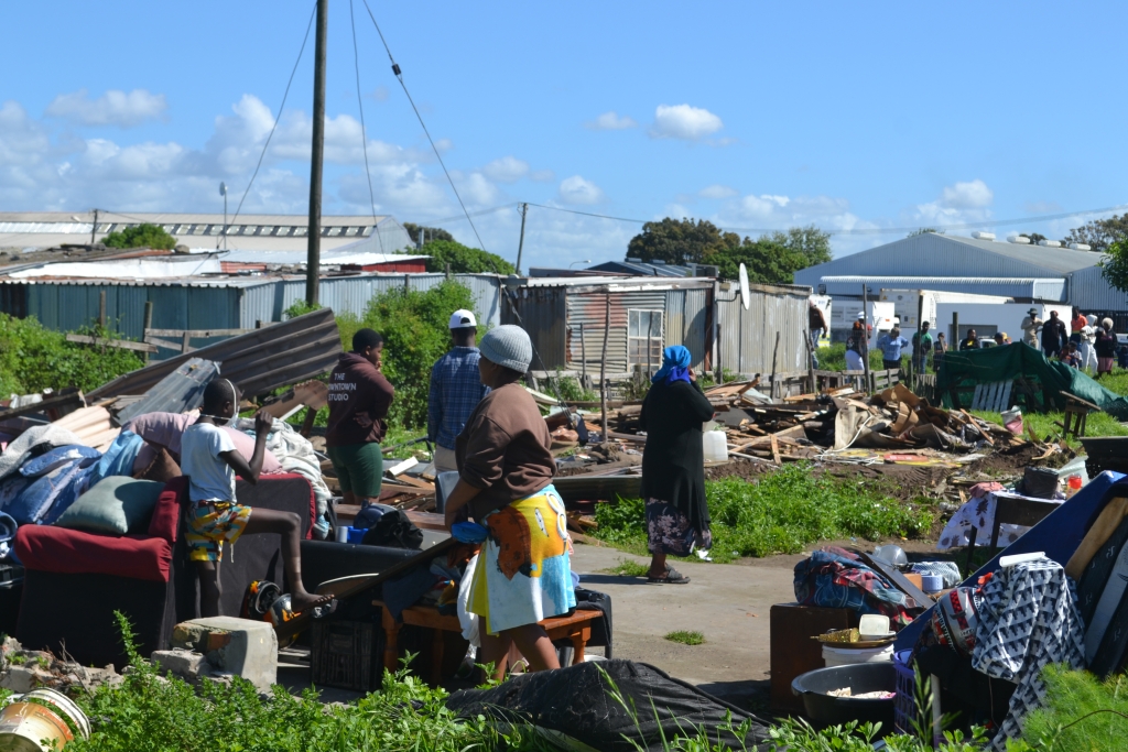 Residents stay close to their belongings after their informal structures were demolished.