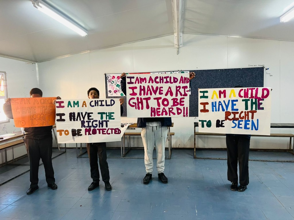Young people holding placard appealing for an end to violence on children. Photo: Supplied