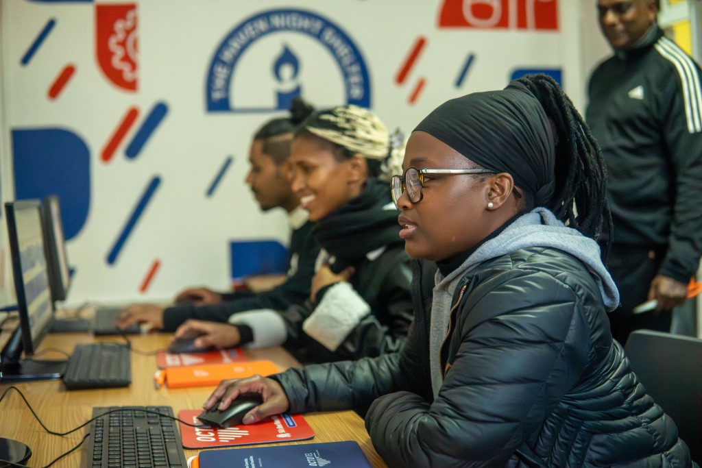 Beneficiaries of the Haven Night Shelter working on desktop computers in a newly equipped digital lab.